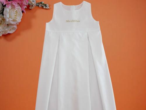 Taufkleid mit Name in gold auf Vorderteil nah